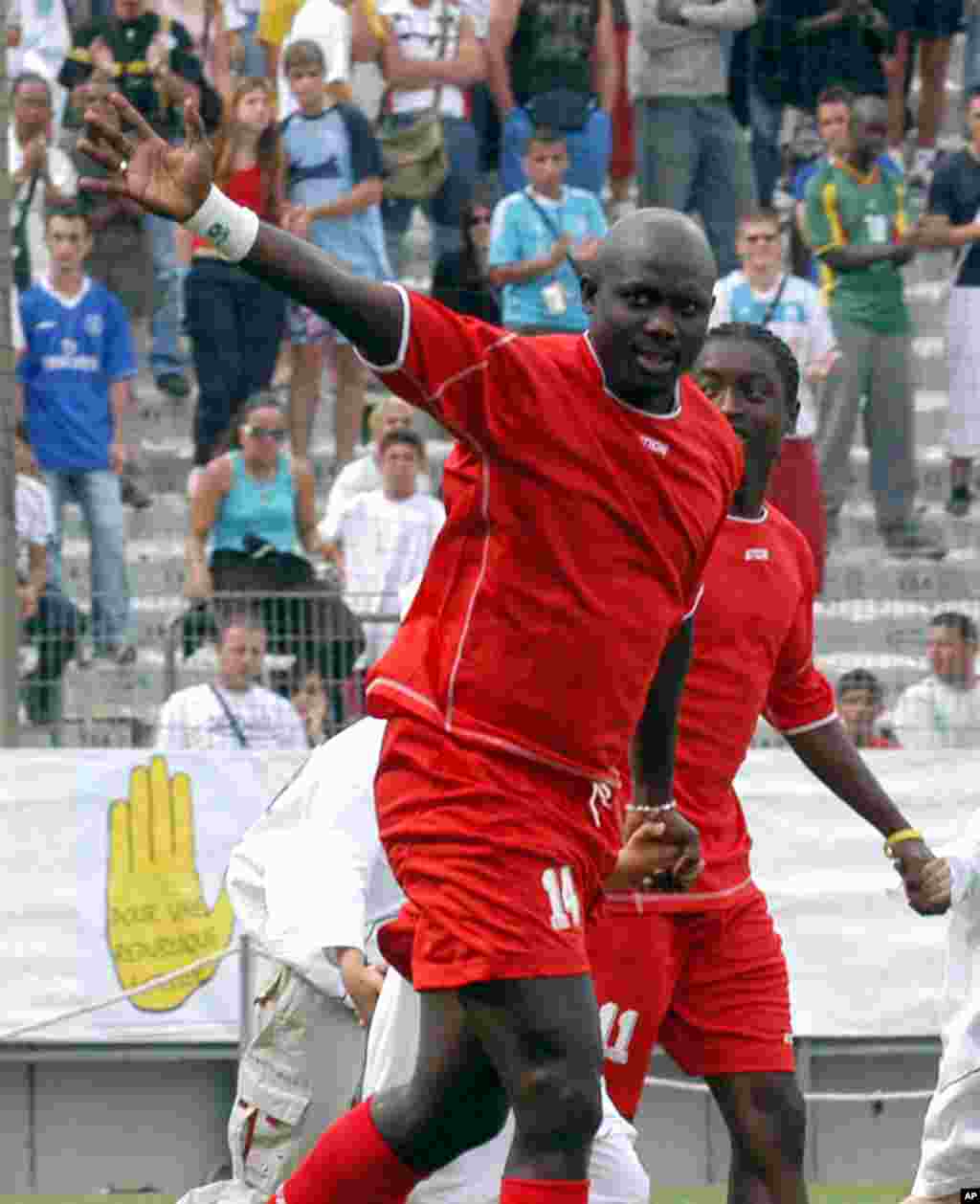 L'ancien footballeur libérien George Weah , à droite, salue la foule au cours du match de son jubilé joué à Marseille, au Sud de la France, samedi 11 juin 2005. Weah a annoncé sa candidat aux prochaines élections pour le Sénat après au Liberia.
