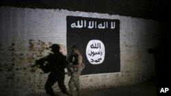 Seorang tentara Irak memeriksa bekas lorong kereta yang dipasangi lambang ISIS di barat Mosul, Irak, 1 Maret 2017. 