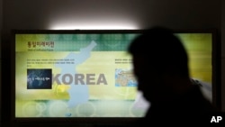 Un hombre pasa por un mapa de la península de Corea en el Puesto de Observación de Unificación cerca de la zona desmilitarizada entre las dos Coreas en Paju, al norte de Seúl.