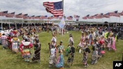 Para penari dari suku asli Amerika yang tinggal di lebih dari 20 tempat reservasi di North dan South Dakota tampil sebelum kedatangan Presiden Obama dan Ibu Negara di Standing Rock Indian Reservation, Cannon Ball, North Dakota, Juni 2014.