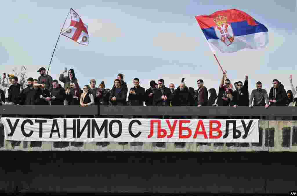 Transparent s natpisom "Ustanimo s ljubavlju" okačen je preko ograde jedne od saobraćajnica na Autokomandi (Photo by Andrej ISAKOVIC / AFP)