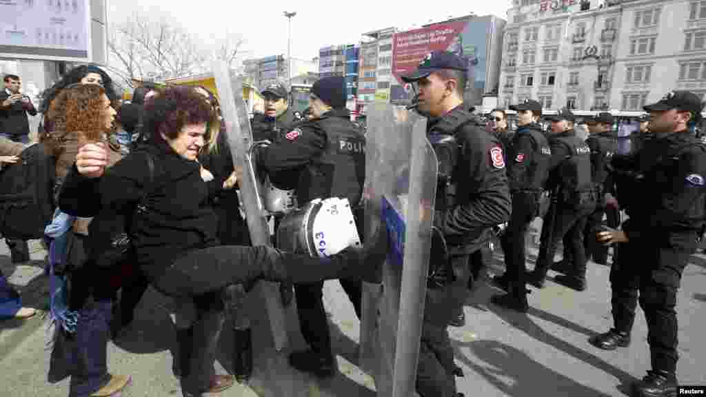 Para demonstran dihentikan polisi dalam sebuah protes menjelang Hari Perempuan Internasional di Istanbul, Turki (6/3). (Reuters/Osman Orsal)