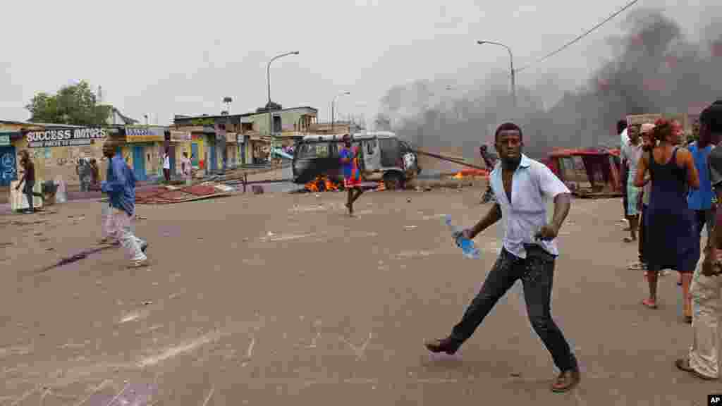 Des manifestants anti gouvernementaux brûlent des pneus et un véhicule lors d'une manifestation contre la modification de la loi électorale qui pourrait retarder l'élection prévue en 2016, dans la ville de Kinshasa, République démocratique du Congo, le lundi 19 janvier 2015,