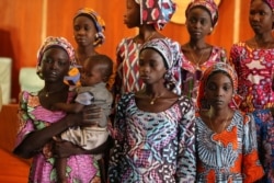 FILE - One of the 21 Chibok schoolgirls recently released by Boko Haram carries her baby during their visit to meet President Muhammadu Buhari In Abuja, Nigeria, Oct. 19, 2016.