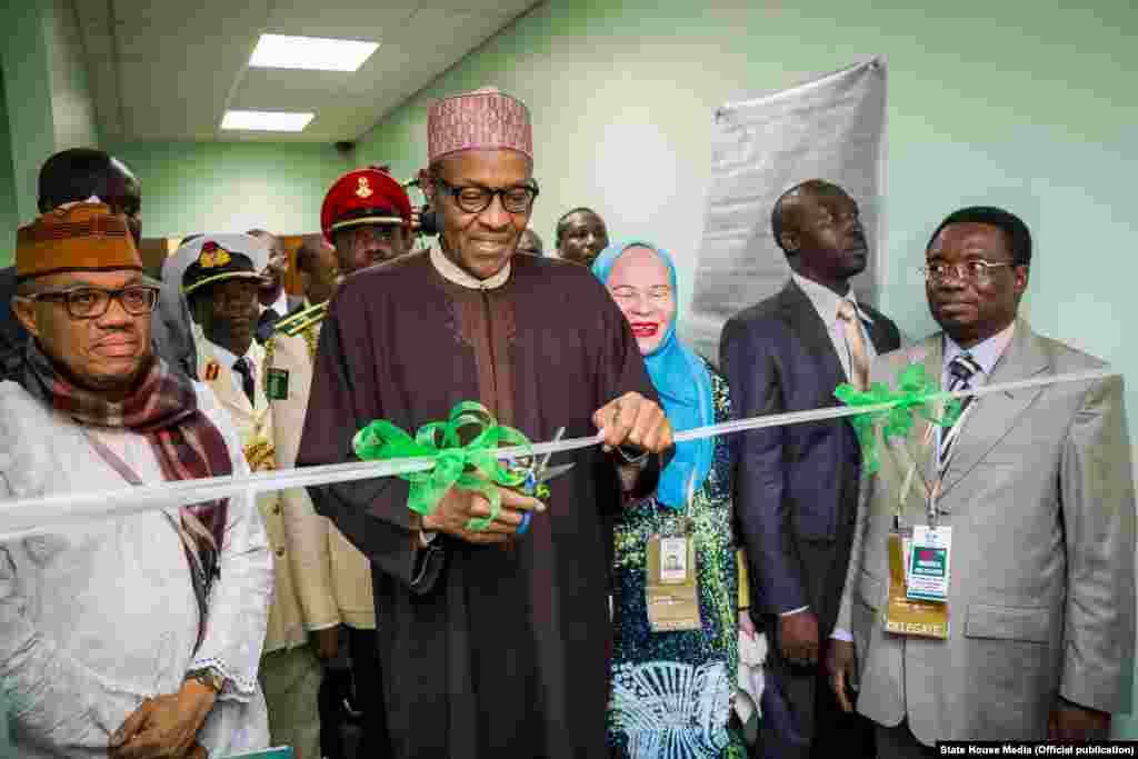 Shugaba Muhammadu Buhari yana bude Cibiyar Ayyukan Shige da Ficen Baki ta Najeriya tare da karamar jakadiya Mrs Uche Ajulu-Okeke da mai rikon mukamin babban jakadan Najeriya a Afirka ta Kudu, Mr. Martins Cobham a lokacin da ya gana da al'ummar Najeriya a karamin ofishin jakadancin Najeriya na Johannesburg a Afirka ta Kudu.
