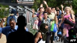 A group of pedestrians ask the activists blocking the avenue to let them cross the street during clashes between opposition demonstrators and riot police in Caracas on July 10, 2017.