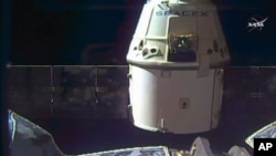 FILE - In this frame grab taken from NASA Television, a SpaceX Dragon capsule separates from a robotic arm of the International Space Station en route back to Earth with a load of science experiments and gear from the space station, Aug. 26, 2016.