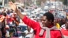 Le leader de l'opposition zambienne Hakainde Hichilema salue ses partisans après avoir été libéré de prison, les accusations de trahison portées contre lui ayant été abandonnées, le 16 août 2107 à Lusaka. 