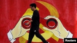 一名男子从上海街头中共党徽前走过。（2019年9月25日）