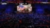Delegates watch a video presentation during an abbreviated session of the Republican National Convention in Tampa, Florida, on Monday, Aug. 27, 2012.