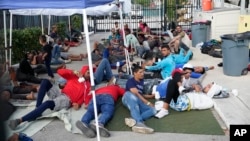 Recently arrived migrants wait in a garage area of the U.S. Customs and Border Protection - Marathon Border Patrol Station, Jan. 4, 2023, in Marathon, Florida.