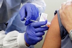 A subject receives a shot in the first-stage safety study clinical trial of a potential vaccine by Moderna for COVID-19, the disease caused by the new coronavirus, at the Kaiser Permanente Washington Health Research Institute in Seattle.