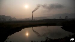 Smoke rises from a brick kiln on the outskirts of Gauhati, India, Monday, Jan. 26, 2015. The World Meteorological Organization reports greenhouse gas concentrations in the atmosphere last year hit a new high and 2015 looks as though it will be another record-breaking year for gases that cause global warming. 