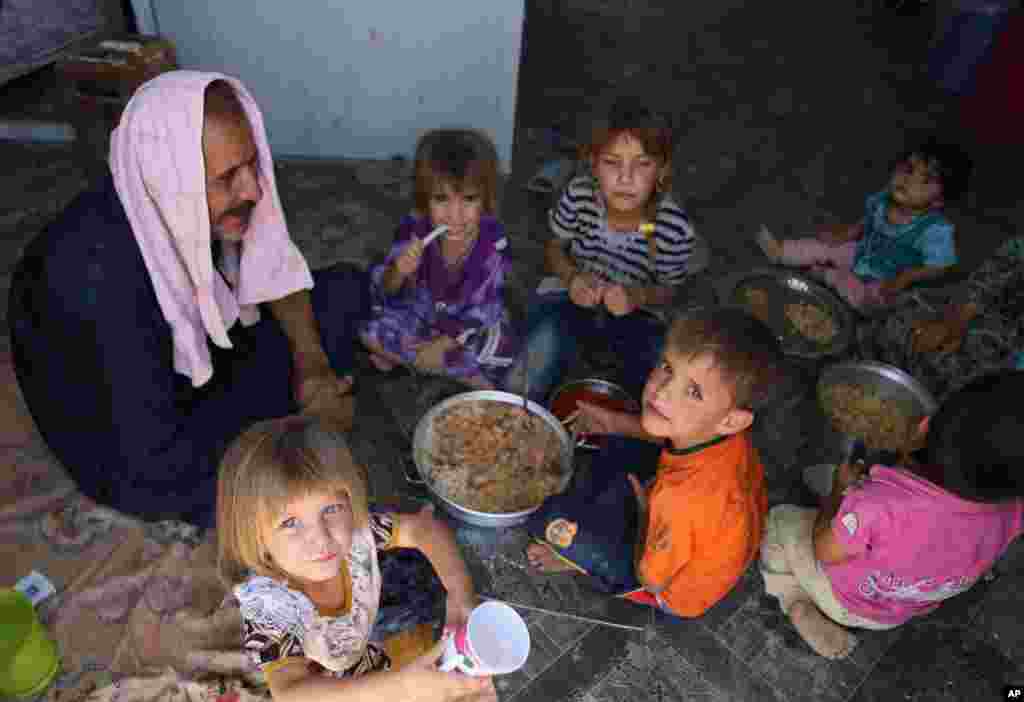 A Iraqi Shi'ite family who fled from Mosul after the advance of Islamic militants, at a refugee camp in Baghdad's southeast suburb of Nahrawan, Aug. 17, 2014.