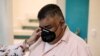 Erwin Pozuelos, quien posee una escuela técnica con su esposa Aura Cartagena, reacciona mientras ella ajusta su mascarilla cuando está de pie en su casa, que pusieron a la venta, durante la pandemia de la enfermedad por coronavirus, en Ciudad de Guatemala, 18 de agosto de 2020.