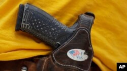 FILE - A man wears an unloaded pistol during a pro gun-rights rally in Austin, Texas, April 14, 2018. 