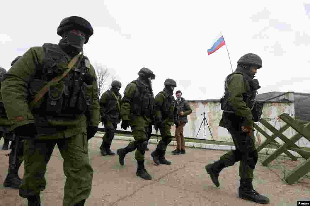 Uniformed men, believed to be Russian servicemen, walk in formation near a Ukrainian military base in Perevalnoye, outside Simferopol, March 6, 2014.