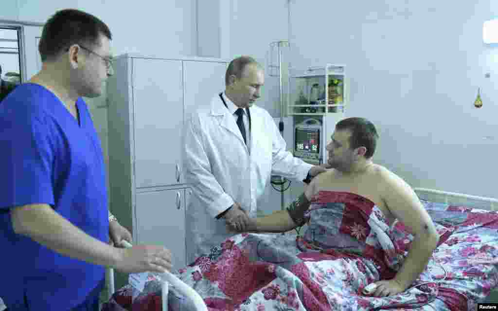Russian President Vladimir Putin (C) shakes hands with a man injured in a bomb blast, Volgograd, Russia, Jan. 1, 2014.