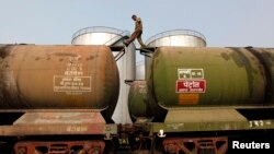Seorang pekerja India memeriksa tangki-tangki minyak mentah yang diimpor dari Iran di Kolkata, India (27/11). India berharap untuk meningkatkan impor minyak mentah dari Iran. 