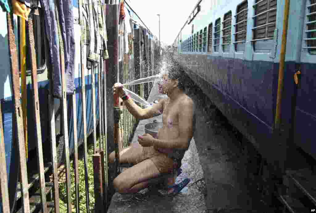 An Indian passenger takes a bath at a railway station during a severe heat wave where temperatures have reached 48 degrees Celsius, in Jammu, May 25, 2015. 