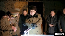 Le leader nord-coréen Kim Jong Un avec des officiels, dans un lieu inconnu. Photo de l'agence officielle KCNA, datée du 11 mars 2016.