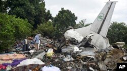 Quelques personnes fouillent les restes de l'épave d'un avion-cargo qui est écrasé dans la capitale, Juba, Sud-Soudan, 4 novembre 2015. (AP Photo/Jason Patinkin) 
