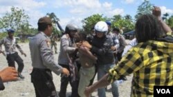 Polisi menangkap seorang warga yang menghadiri perayaan 50 tahun Kemerdekaan Papua dari penjajahan Belanda di Timika ( 1/12).