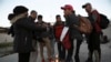 Migrantes de diferentes naciones se reúnen cerca del muro fronterizo en Ciudad Juárez, México, el 21 de diciembre de 2022, al otro lado de la frontera desde El Paso, EEUU.