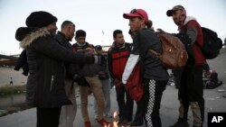 Migrantes de diferentes naciones se reúnen cerca del muro fronterizo en Ciudad Juárez, México, el 21 de diciembre de 2022, al otro lado de la frontera desde El Paso, EEUU.