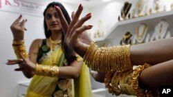 Dua orang model memeragakan perhiasan emas yang dikenakannya dalam sebuah pameran emas dan permata di Hyderabad, India (7/6).