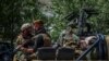 Combatientes talibanes se sientan junto a un vehículo en una calle de la provincia de Laghman el 15 de agosto de 2021.