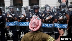 Un manifestante hace un gesto hacia los agentes del Departamento de Policía de Nueva York (NYPD) en apoyo de "Black Lives Matter" en la ciudad de Nueva York, EE.UU. 