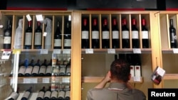 资料照：澳大利亚国库酒庄拥有的Penfolds葡萄酒酒庄店员将葡萄酒放到酒架上陈列。