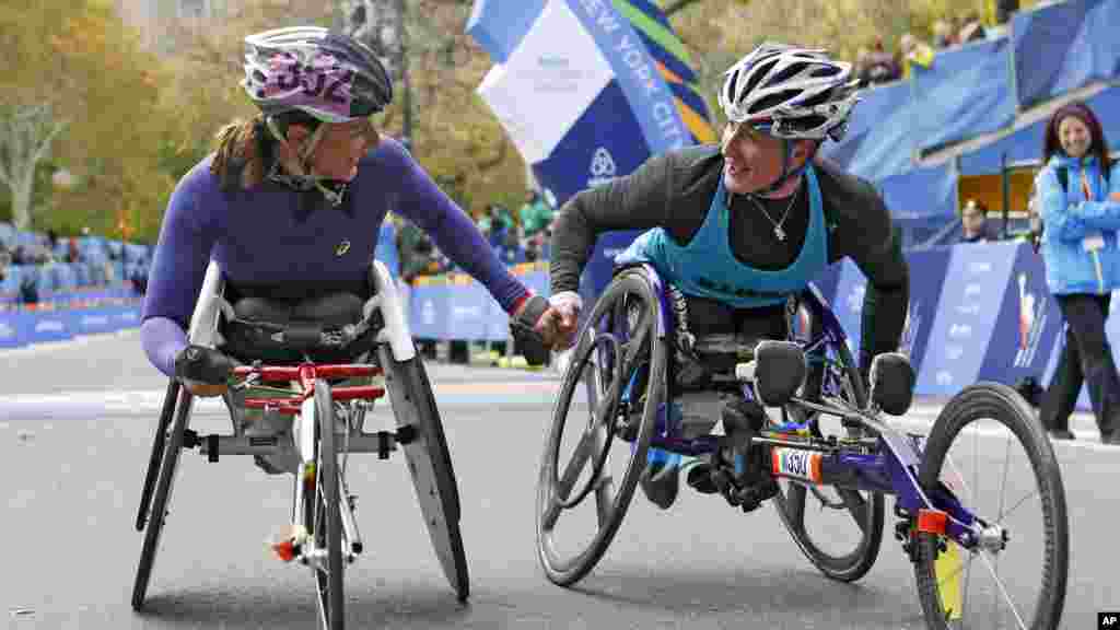 Manuela Schar de la Suisse, à gauche, félicite la championne, Tatyana McFadden des États-Unis. Les deux ont pris part à la course en fauteuil roulant, version dames, du 44eme marathon de New York à New York, le 2 novembre 2014.