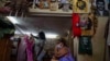 FILE - A woman waits to be shown a dress in a private clothing store in Havana, Cuba, Sept. 16, 2021. The United States said on May 28, 2024, that regulatory changes will allow Cuba’s independent private sector entrepreneurs to open and remotely access U.S. bank accounts.