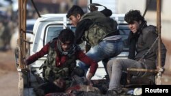 Pejuang Angkatan Darat Suriah menaiki truk pick-up dengan seorang rekan tempur yang terluka dalam serangan di pinggiran kota Suriah utara, Al-Bab, 10 Januari 2017.