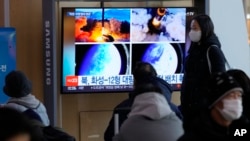 한국 서울역 이용객들이 북한 탄도미사일 발사 뉴스를 시청하고 있다. (자료사진)