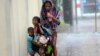 A mother takes refuge with her children as Typhoon Haiyan hits Cebu city, central Philippines, Nov. 8, 2013. 