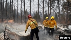 Bomberos remueven escombros mientras recuperan restos humanos de una casa rodante destruida por el incendio Camp, en Paradise, California. Noviembre 17 de 2018.