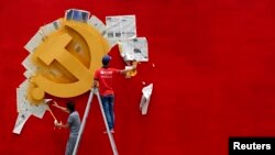 浙江省嘉興南湖革命紀念館的兩名工人在牆上漆一面中共黨旗。（路透社照片）