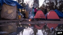En la foto de archivo se ve a un niño junto a un fuego en un campamento de solicitantes de asilo mexicanos en el Parque Chamizal cerca del Puente de las Américas en Ciudad Juárez, México.
