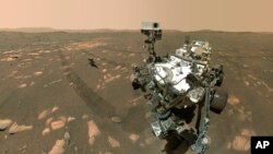 Esta imagen proporcionada por la NASA el 6 de abril de 2021, muestra a la sonda Perseverance en primer plano y al helicóptero Ingenuity unos 3,9 metros detrás. 