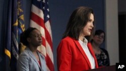 In a photo provided by the Michigan Office of the Governor, Michigan Gov. Gretchen Whitmer delivers a speech in Lansing, Michigan, April 22, 2020.