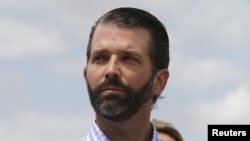 Donald Trump Jr escucha a su padre el presidente Donald Trump durante una visita a Lake Okechobee y la represa Herbert Hoover en Canal Point, Florida, el 29 de marzo de 2019.