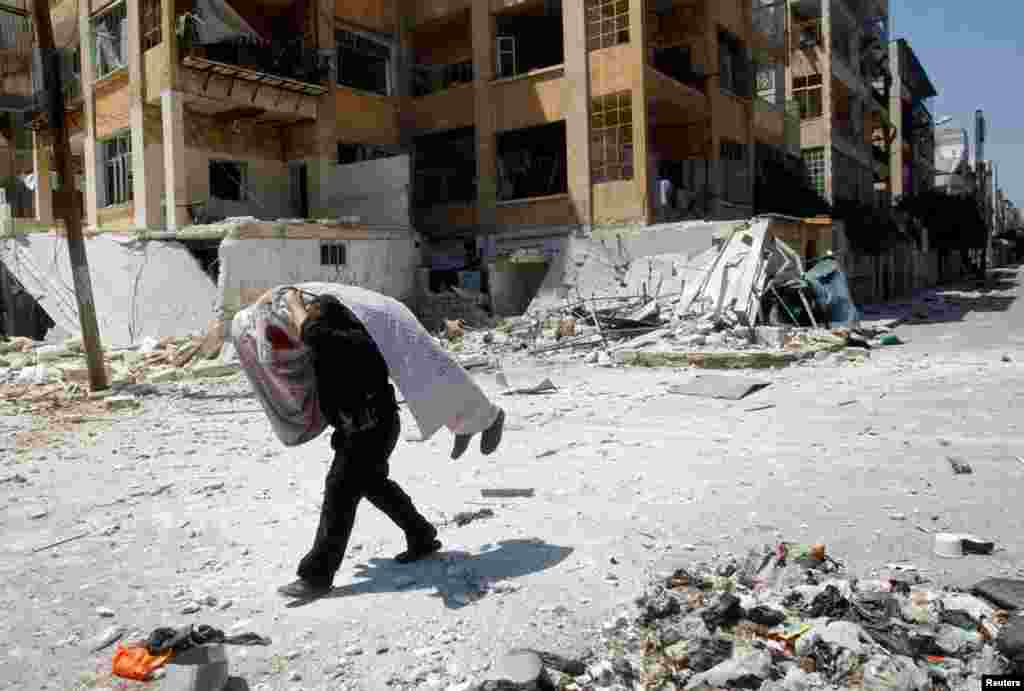 A Free Syrian Army fighter carries the body of a fellow fighter in Aleppo, August 16, 2012.
