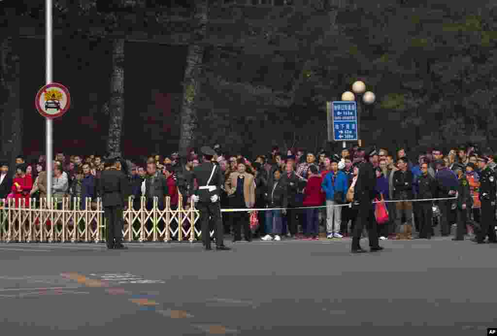 Chinese paramilitary police and uniformed police seal off pavement leading to Tiananmen Gate, following a car fire in Beijing, Oct. 28, 2013.