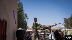 Um soldado do exército sudanês maneja uma metralhadora em cima de uma carrinha militar à porta de um hospital em Omdurman, a 2 de novembro de 2024.