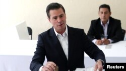 El presidente de México, Enrique Peña Nieto vota en el centro donde está empadronado en Ciudad de México, el 1 de julio de 2018. México elige este día presidente, legisladores y otros altos funcionarios en una histórica votación.