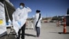 Seorang petugas mengenakan alat pelindung diri baru di fasilitas lantatur tes Covid-19 di El Paso, Texas, 26 Oktober 2020. (Briana Sanchez/The El Paso Times via AP)