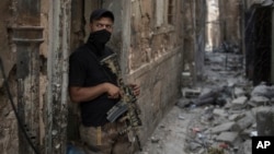 Seorang anggota pasukan khusus Irak siaga di lorong bangunan di Mosul untuk mencari sisa-sisa teroris ISIS di sana (foto: dok). 